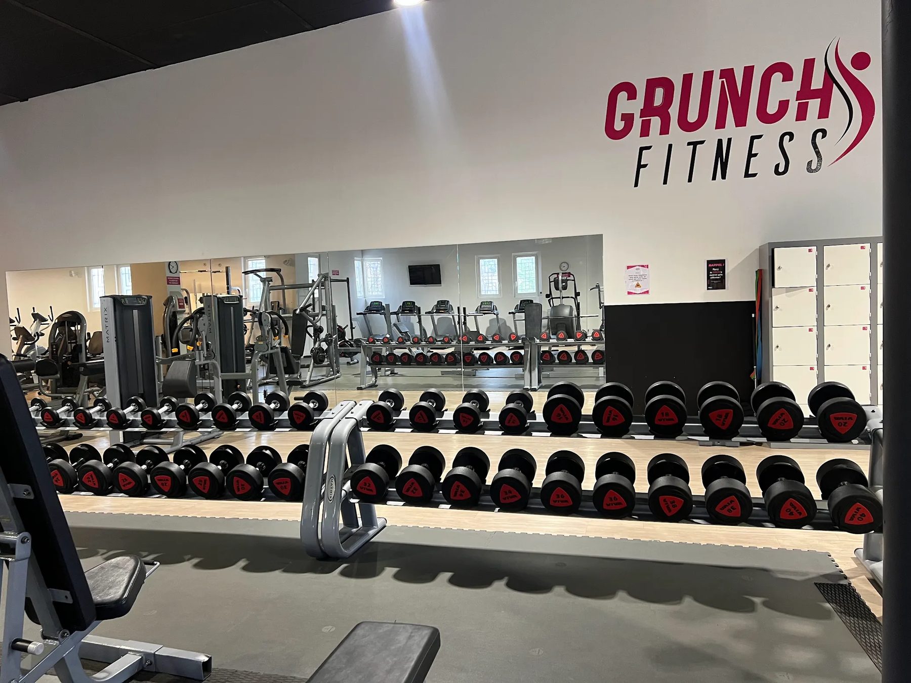 Haltères et logo Grunch Fitness dans la salle